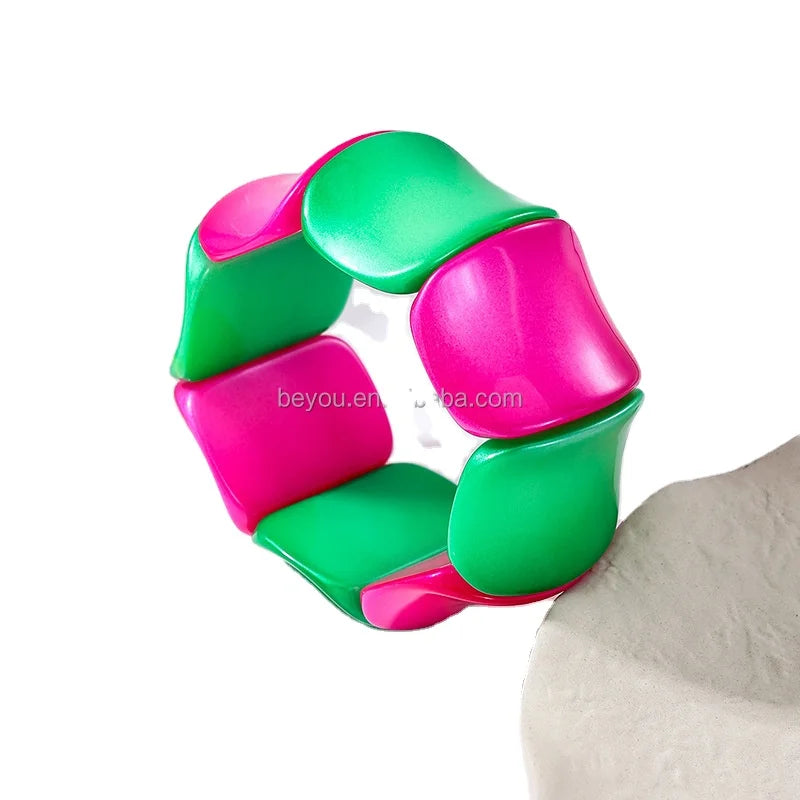 Designer handbag accessory: chunky pink and green resin chain link bracelet, polished finish.