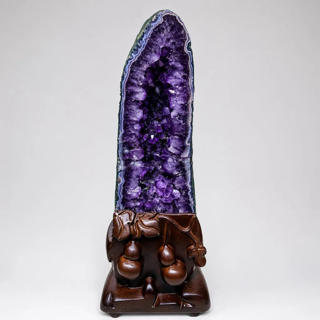 Amethyst geode crystal cluster with purple crystal face on carved wooden base