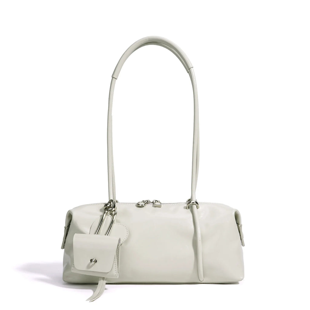 Minimalist white Boston underarm shoulder bag with luxe leather texture, silver zipper, and decorative mini pouch.