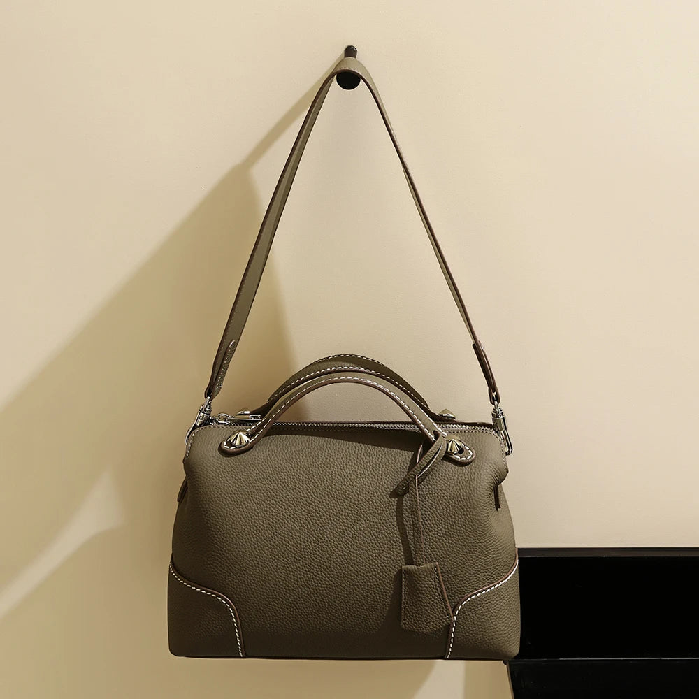 Taupe designer handbag in pebble-grain cowhide leather with contrast stitching and shoulder strap.