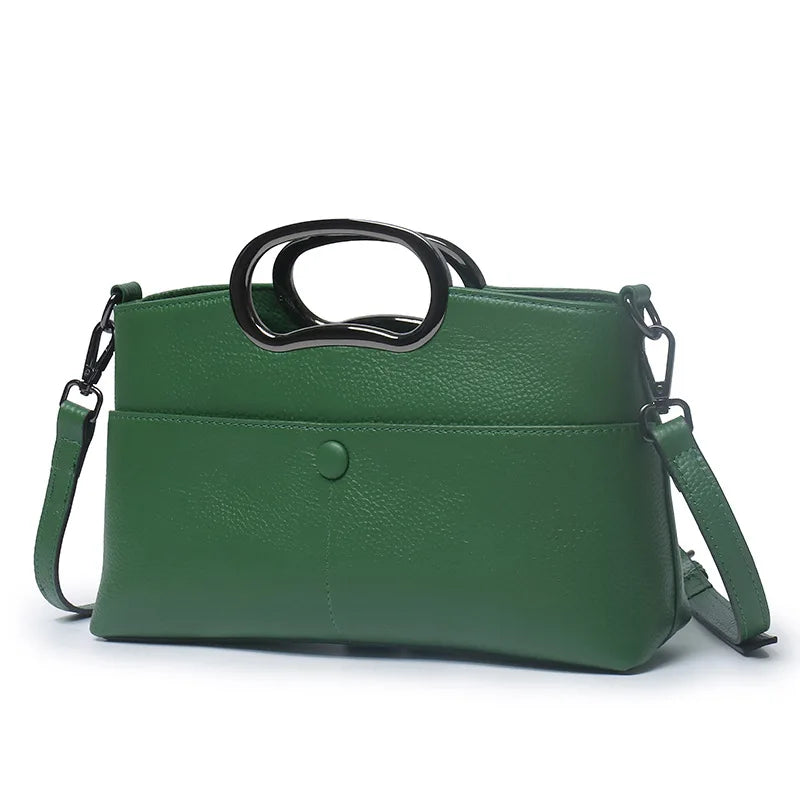 Green designer crossbody handbag in textured PU leather with unique black circular top handles and shoulder strap.