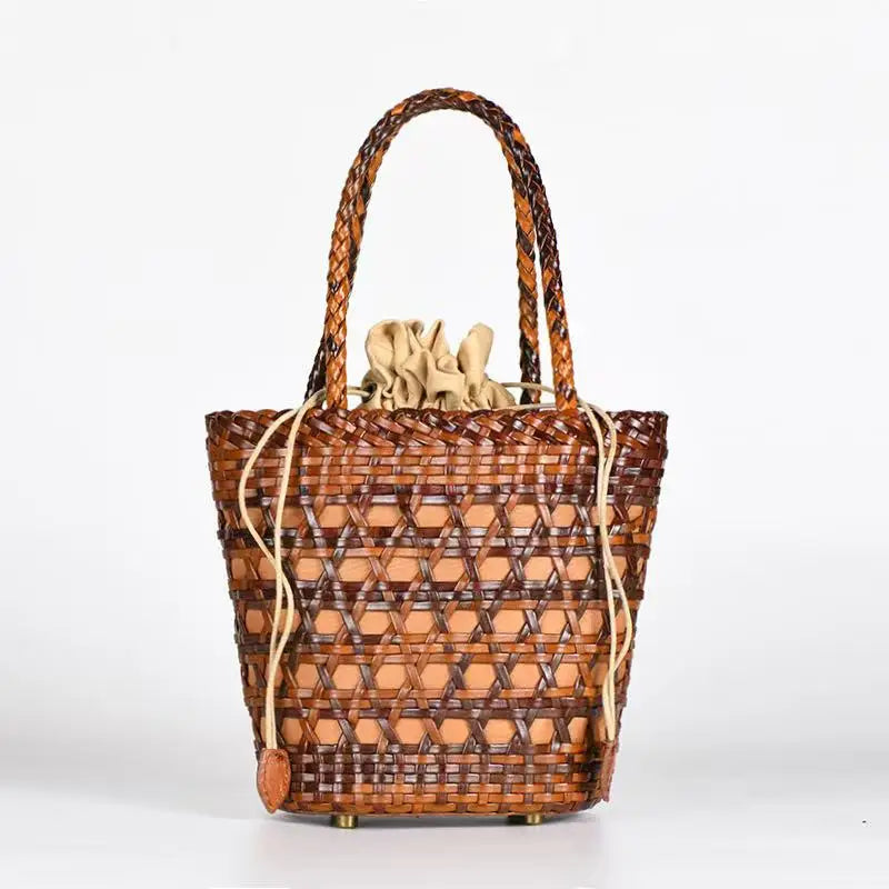 Handwoven brown leather bucket tote with cross-weave cannage design, braided handles, and beige drawstring lining.