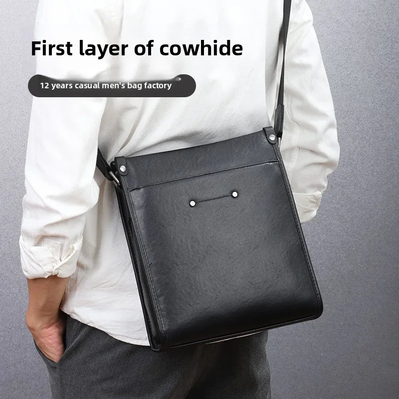 Black genuine cowhide leather crossbody business bag with adjustable shoulder strap and minimalist vertical design.