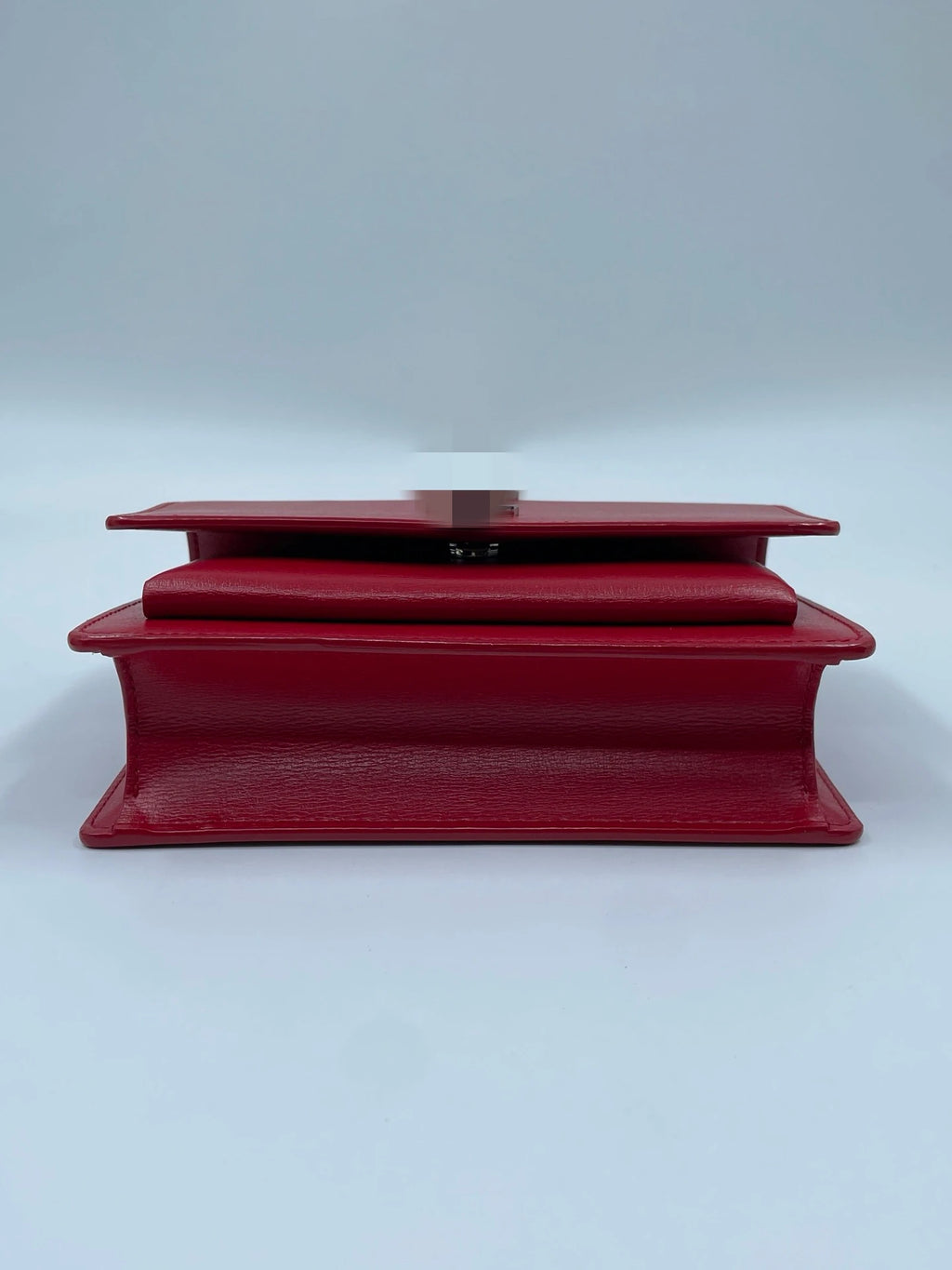 Luxury red genuine leather designer crossbody bag with a structured silhouette and silver hardware accents.