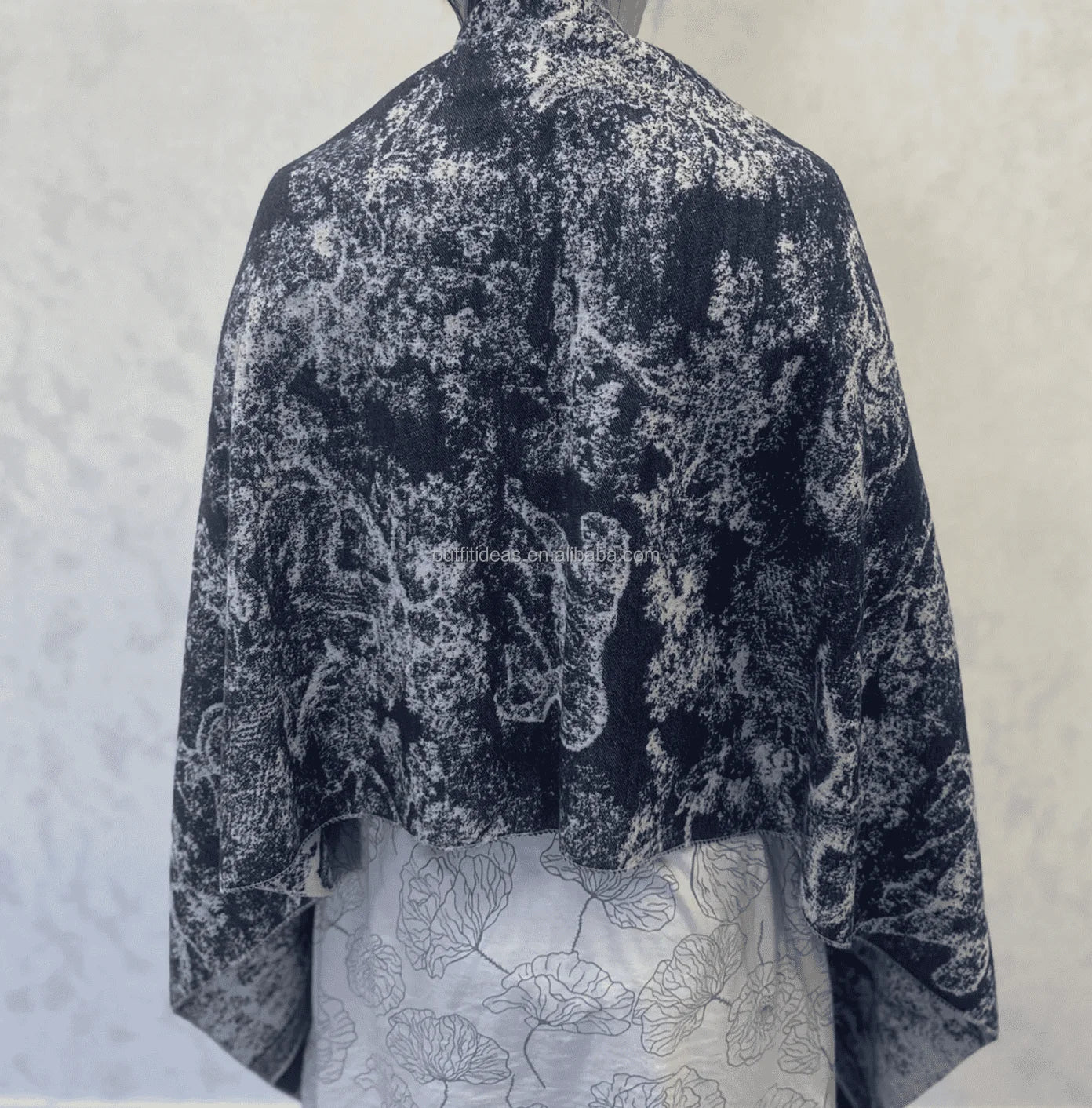 Large luxury silk scarf with black and white abstract marbled print, draped rectangular design.