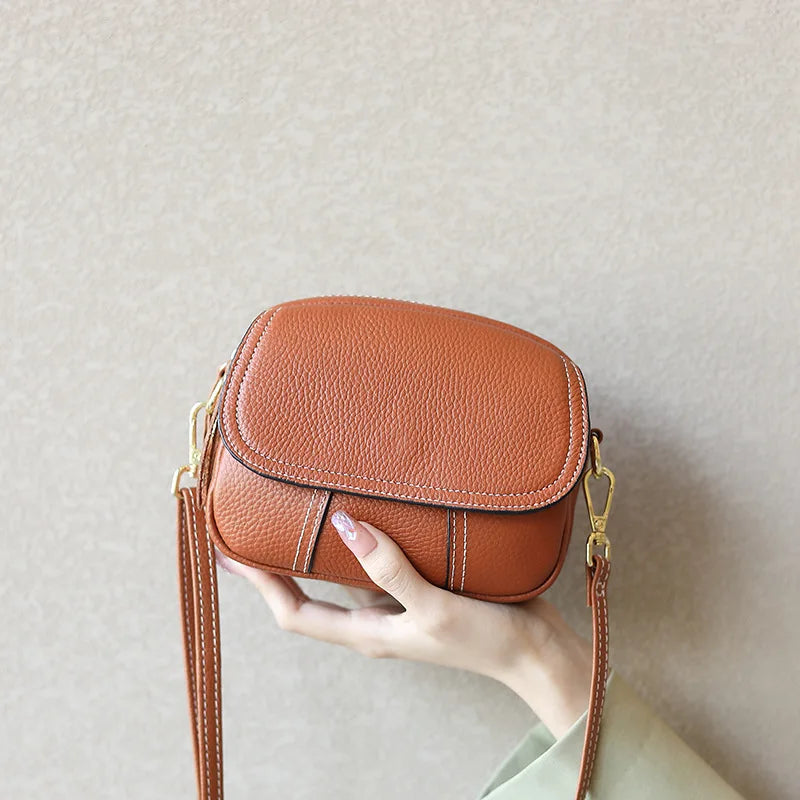 Brown pebbled genuine leather mini crossbody bag with gold hardware, contrast stitching, and retro underarm style.