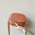 Brown pebbled genuine leather mini crossbody bag with gold hardware, contrast stitching, and retro underarm style.