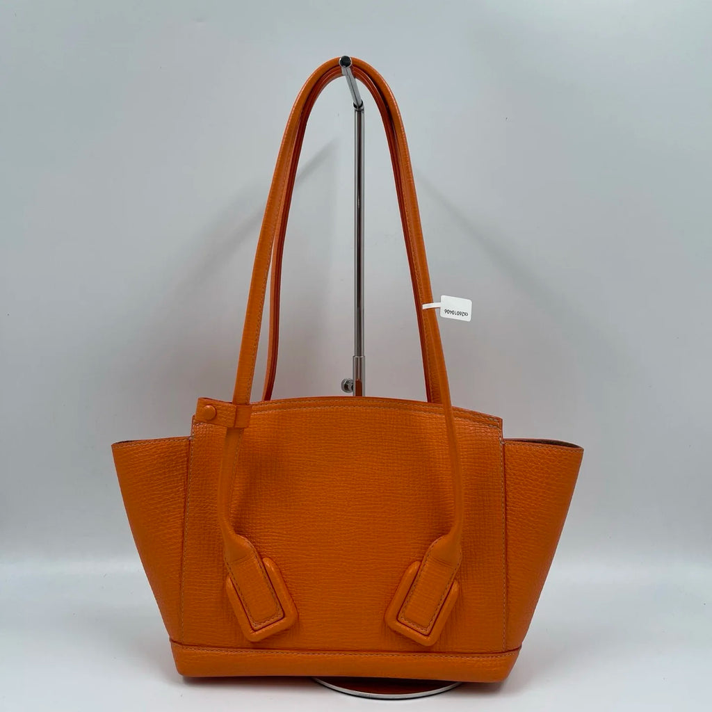 Luxury orange genuine leather designer shoulder tote bag with double handles and flap closure.