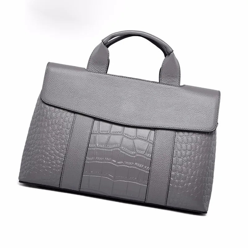 Grey genuine leather designer handbag featuring a flap top and a combination of pebble and crocodile-embossed textures.