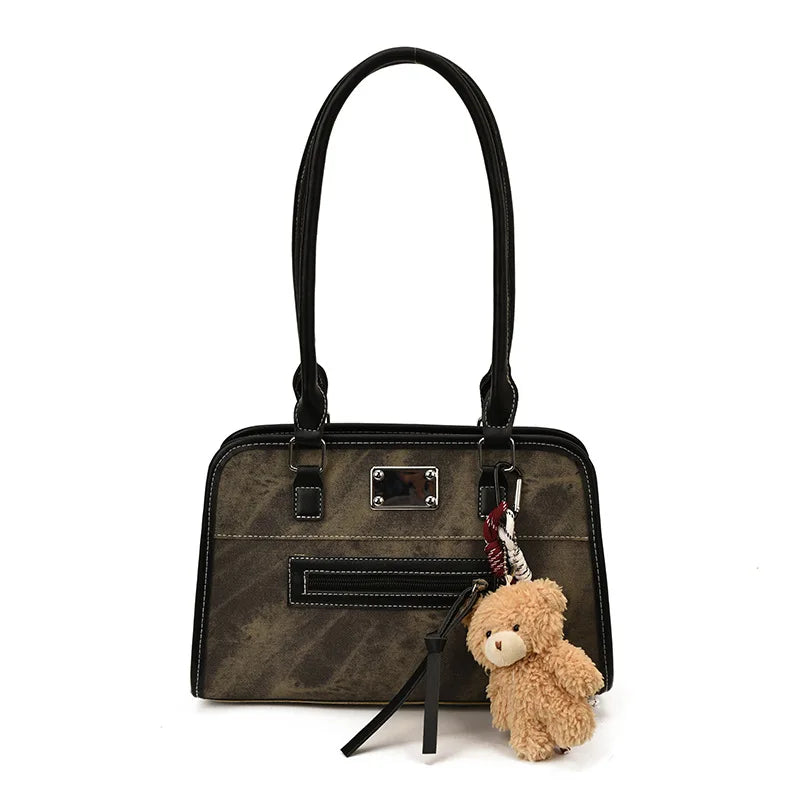 Vintage distressed olive green leather tote with black trim, silver hardware, and cute teddy bear keychain charm.