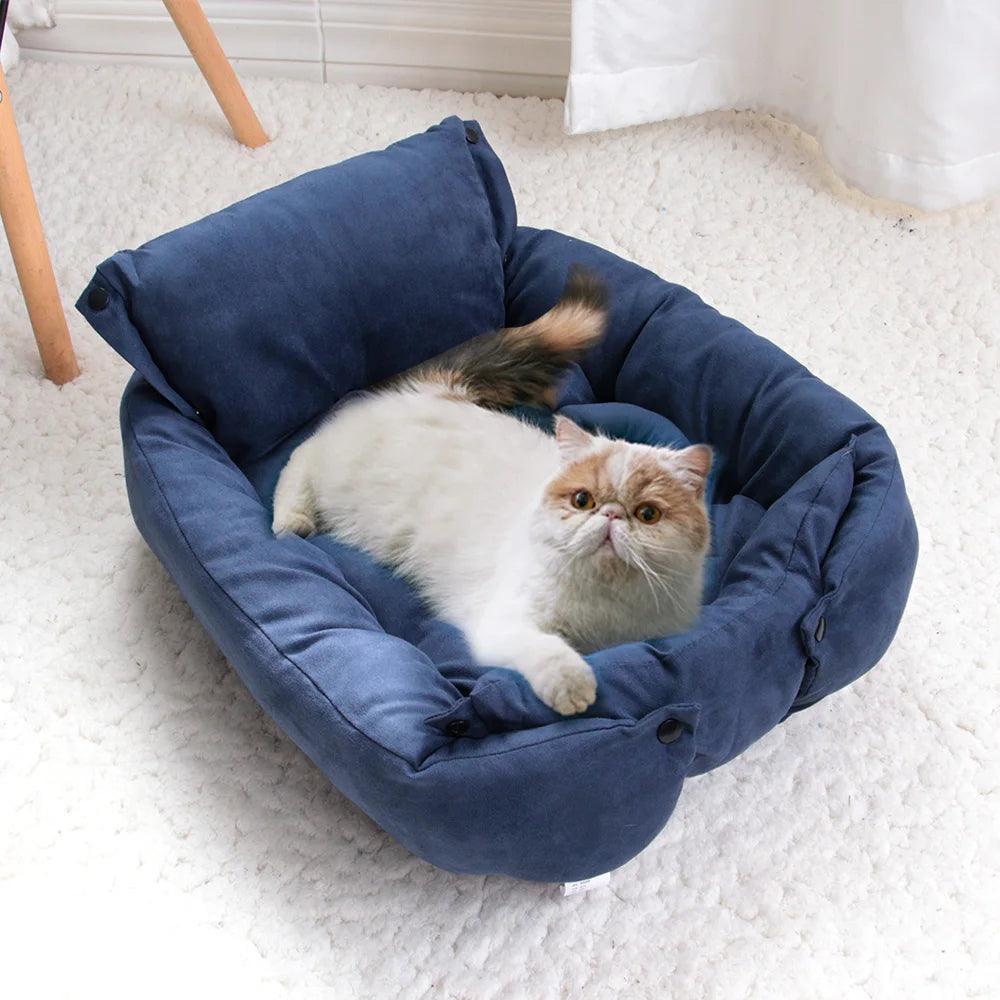 Cat resting in a cozy blue suede sofa bed, a warm and comfortable winter mattress for small dogs and cats.