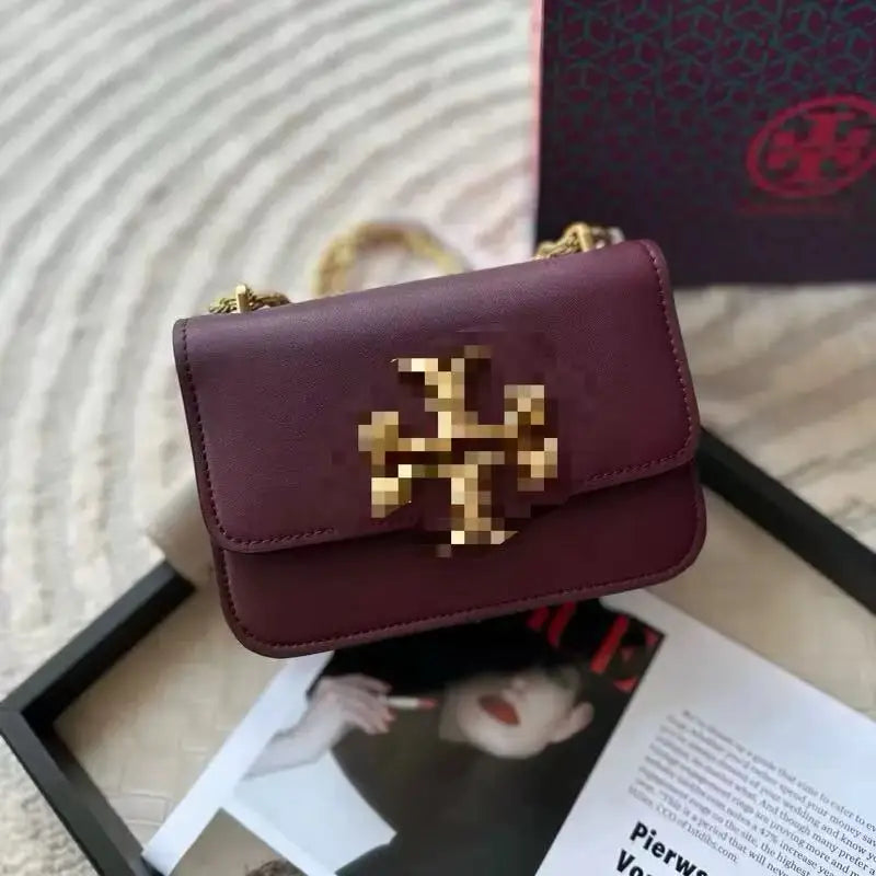 Burgundy leather Zhenwo TB trunk crossbody bag with gold metal logo hardware and chain strap.