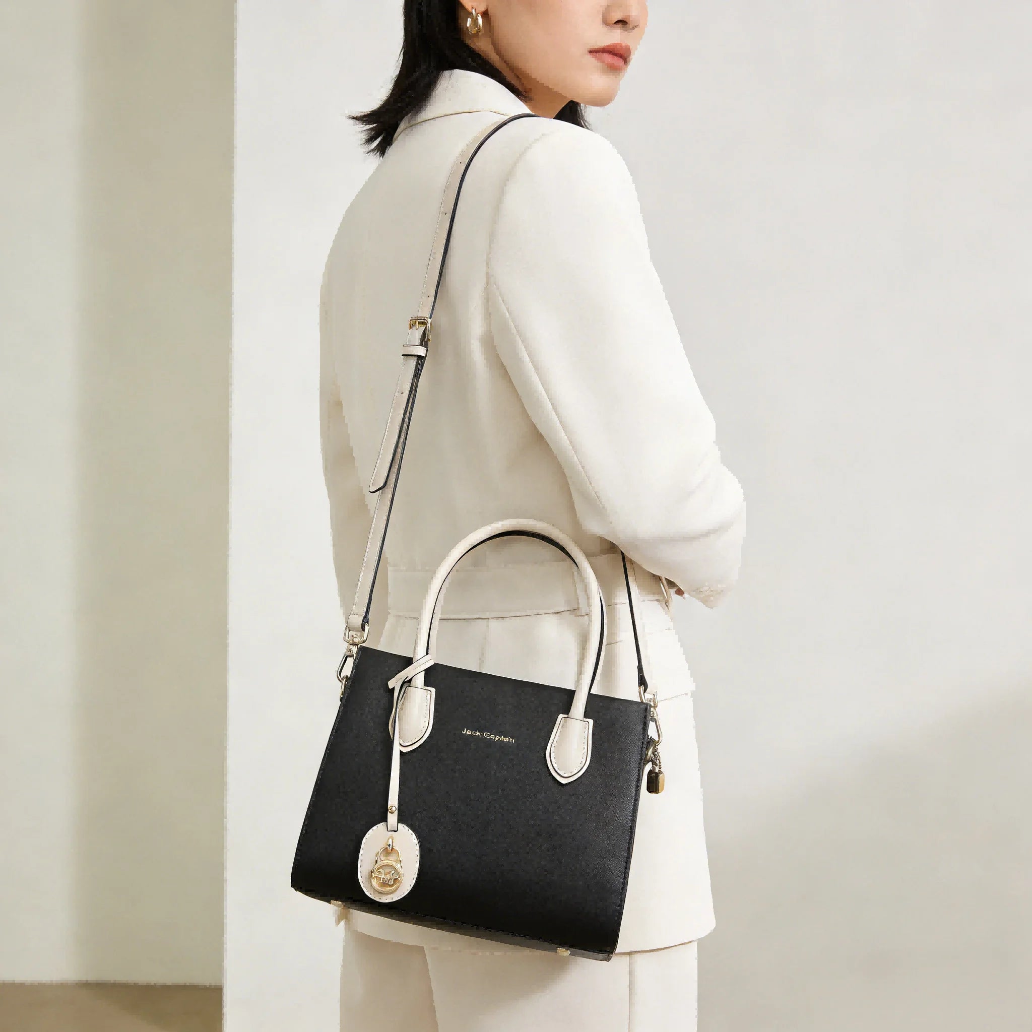 Black leather Jack Captain designer shoulder bag, two-tone tote with white handles and gold charm. Designer Handbags.