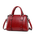 Red genuine cow split leather designer handbag with top handle, detachable shoulder strap, and polished metal hardware.