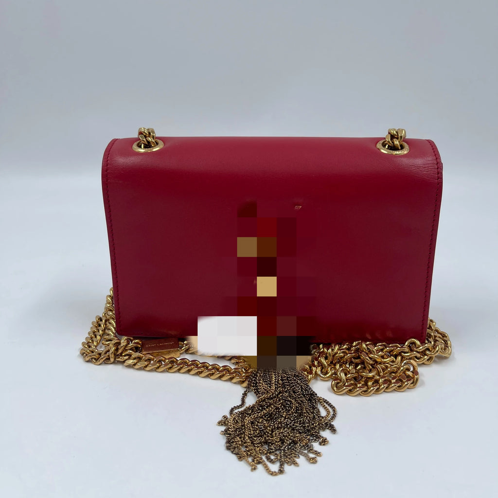 Luxury red leather designer shoulder bag with gold chain strap and tassel, pre-owned square fashion statement piece.