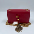 Luxury red leather designer shoulder bag with gold chain strap and tassel, pre-owned square fashion statement piece.