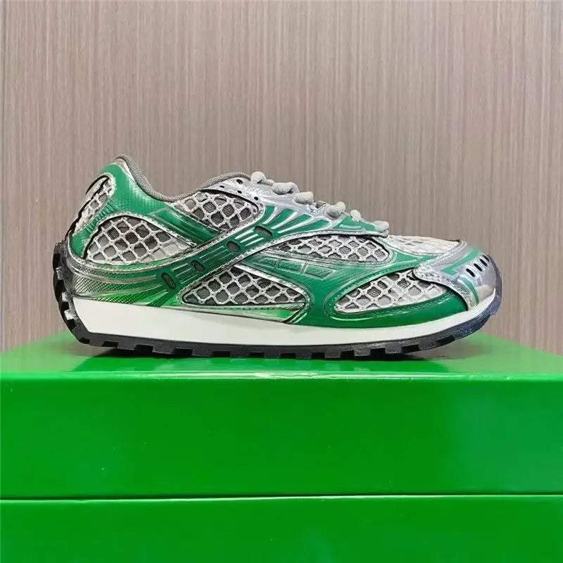 Luxury men's sneakers in green and silver metallic leather with mesh panels on a green designer box.