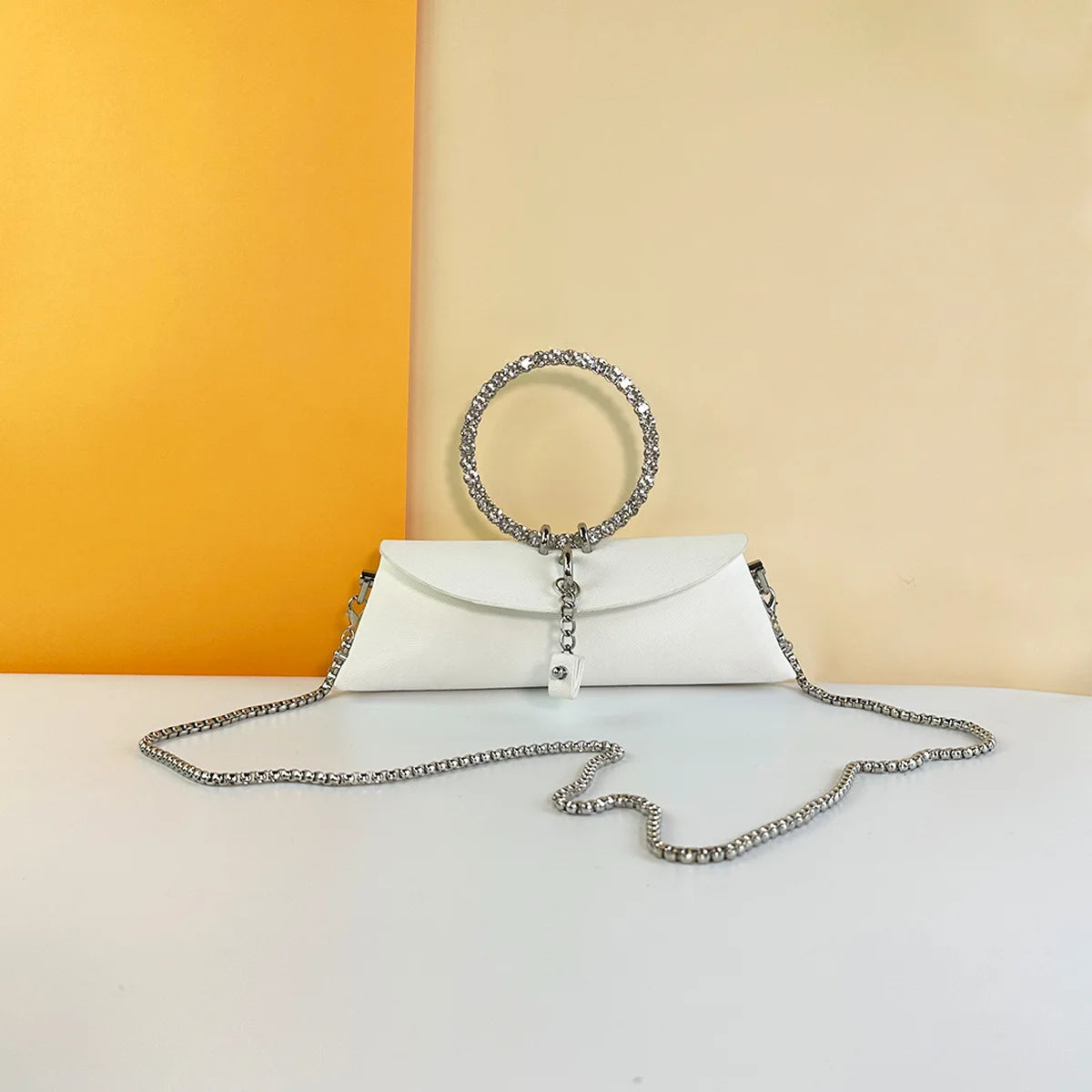 White PU leather clutch with rhinestone ring handle and silver chain strap for weddings or evening events.