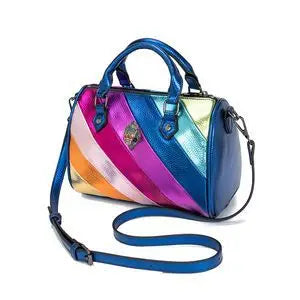 Kurt Geiger metallic trunk bag featuring rainbow striped leather, dual handles, crossbody strap, and crystal eagle logo.