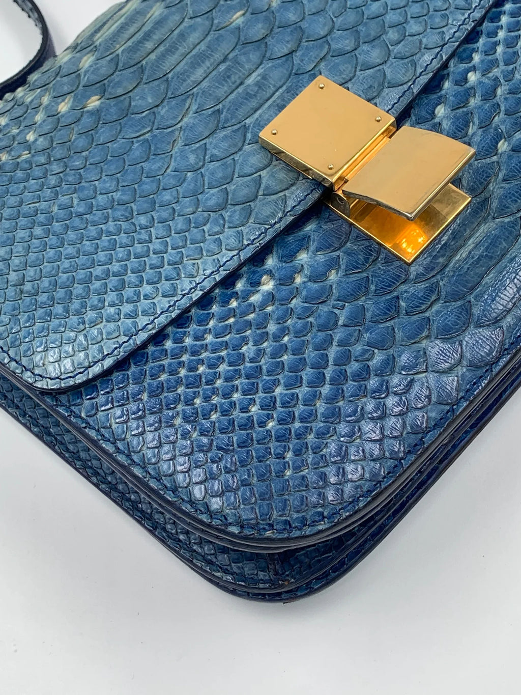 Pre-owned blue snakeskin designer shoulder bag with square gold metal clasp, luxury vintage style.