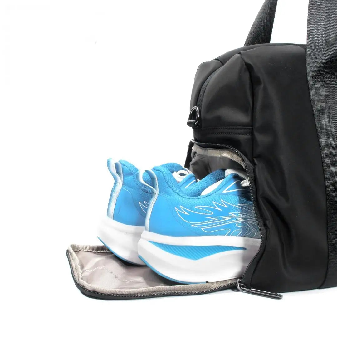 Black waterproof nylon travel duffel bag with a dedicated zippered side shoe compartment for gym or trip organization.