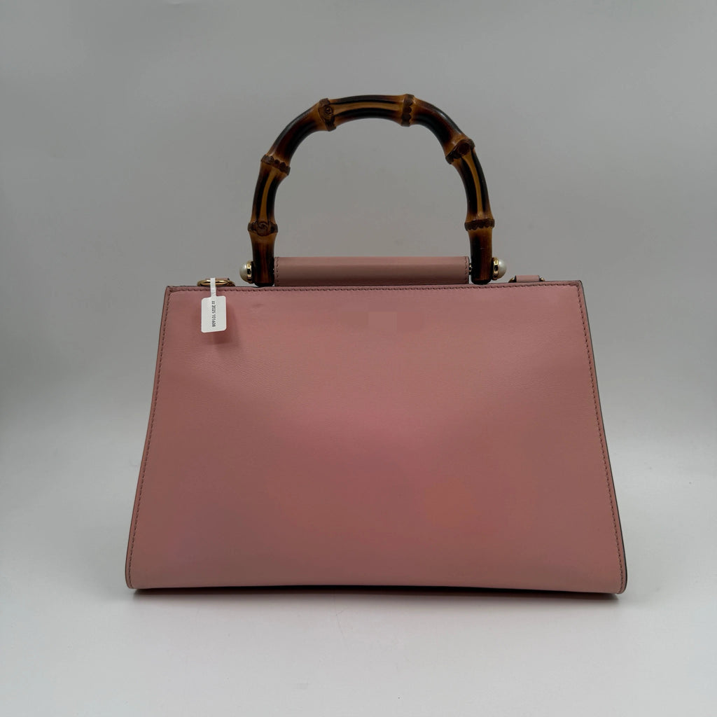 Pre-owned dusty pink designer leather handbag with a signature bamboo top handle and elegant structured silhouette.