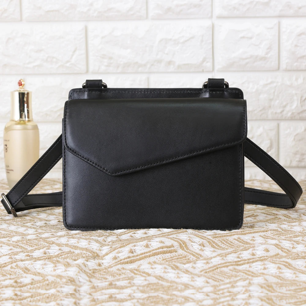 Black genuine cow leather designer crossbody bag with a sleek flap and adjustable strap for women.