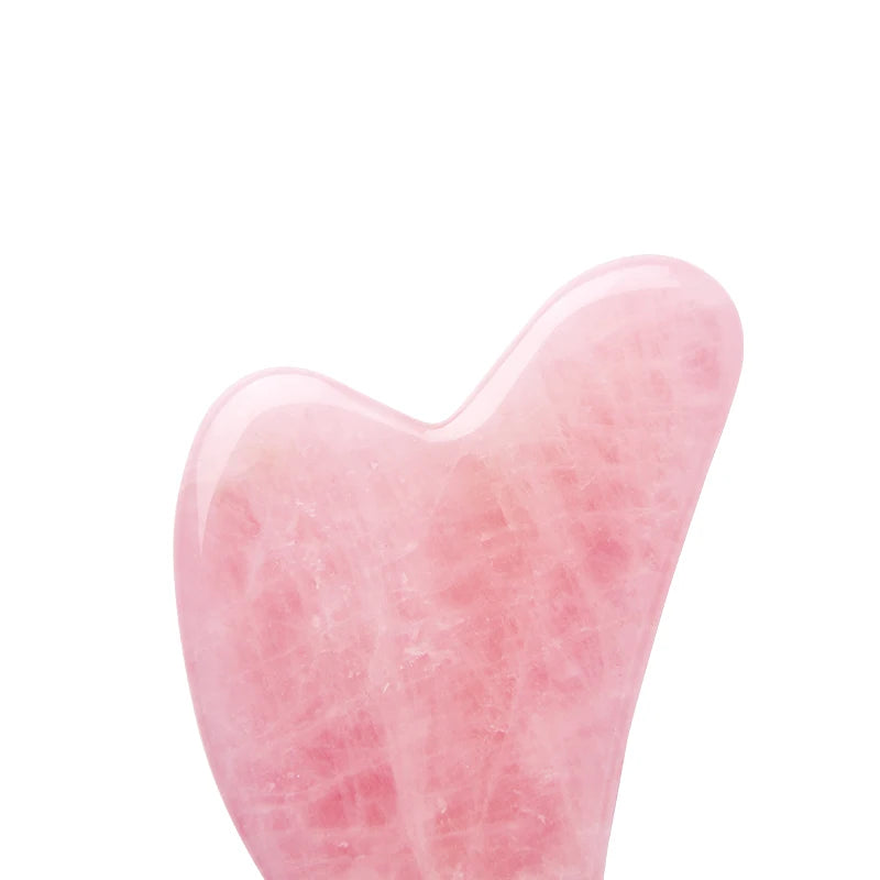 Heart-shaped rose quartz gua sha facial massage tool with a smooth, polished, light pink natural stone texture.