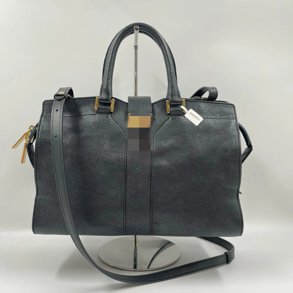 Black genuine leather luxury designer handbag, pillow shape with dual straps, gold hardware, and classic retro style.