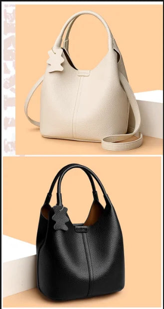 Beige and black pebbled leather bucket bags with top handles, crossbody straps, and cute bear charm luggage tags.