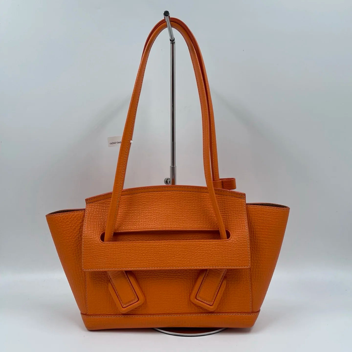Orange genuine leather designer shoulder tote with two handles and a flap closure. Stylish luxury ladies handbag.