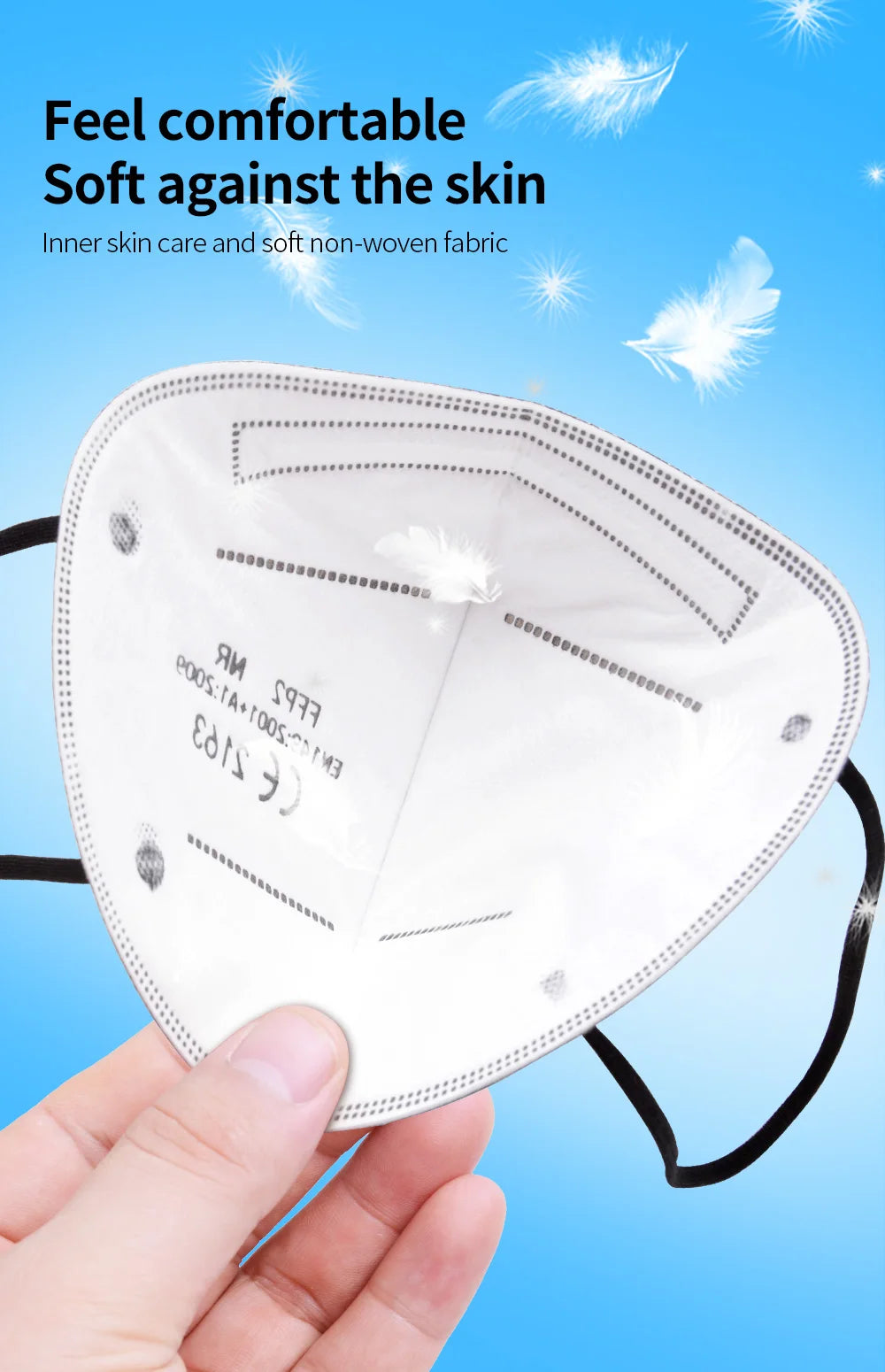 White 5-layer KN95 face mask with soft, non-woven inner fabric and black ear loops, held in a hand.
