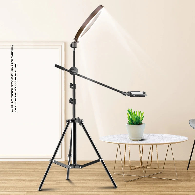 Black metal tripod ring light with an adjustable boom arm and smartphone mount for content creation.