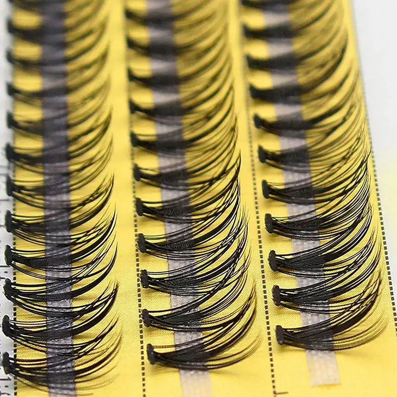 Three rows of black 20D Russian volume eyelash clusters on a yellow adhesive strip.