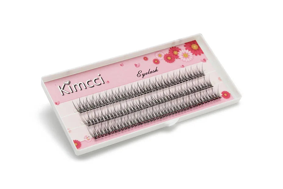 Tray of 120 black Kimcci individual mink flared eyelash extension clusters on a floral pink background.