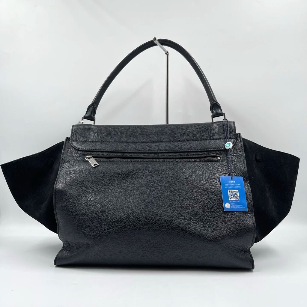 Black lychee texture designer shoulder bag with vintage swing-style suede side wings and a top handle.
