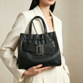 Black genuine leather tote handbag with ruched detail, gold buckle, and top handles for work.