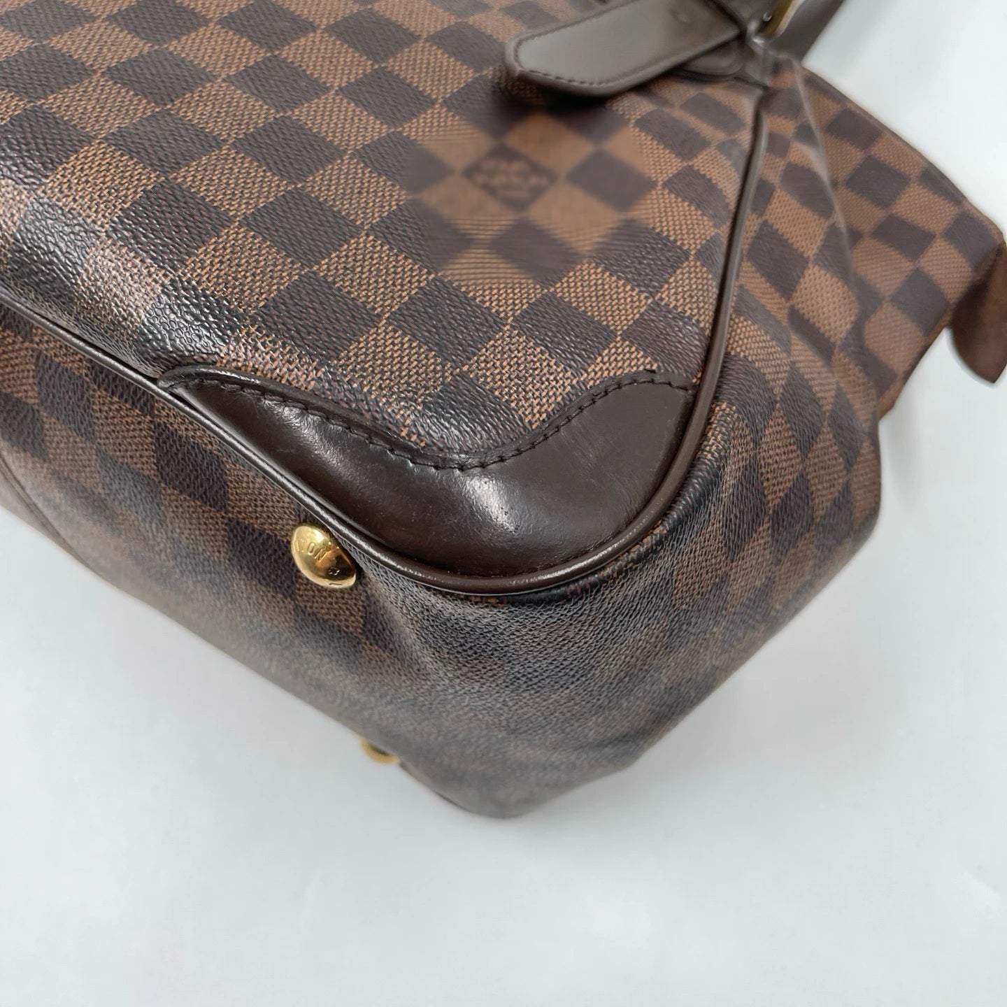 Vintage designer handbag in brown checkerboard canvas with leather trim, gold hardware, and unisex shoulder bag style.