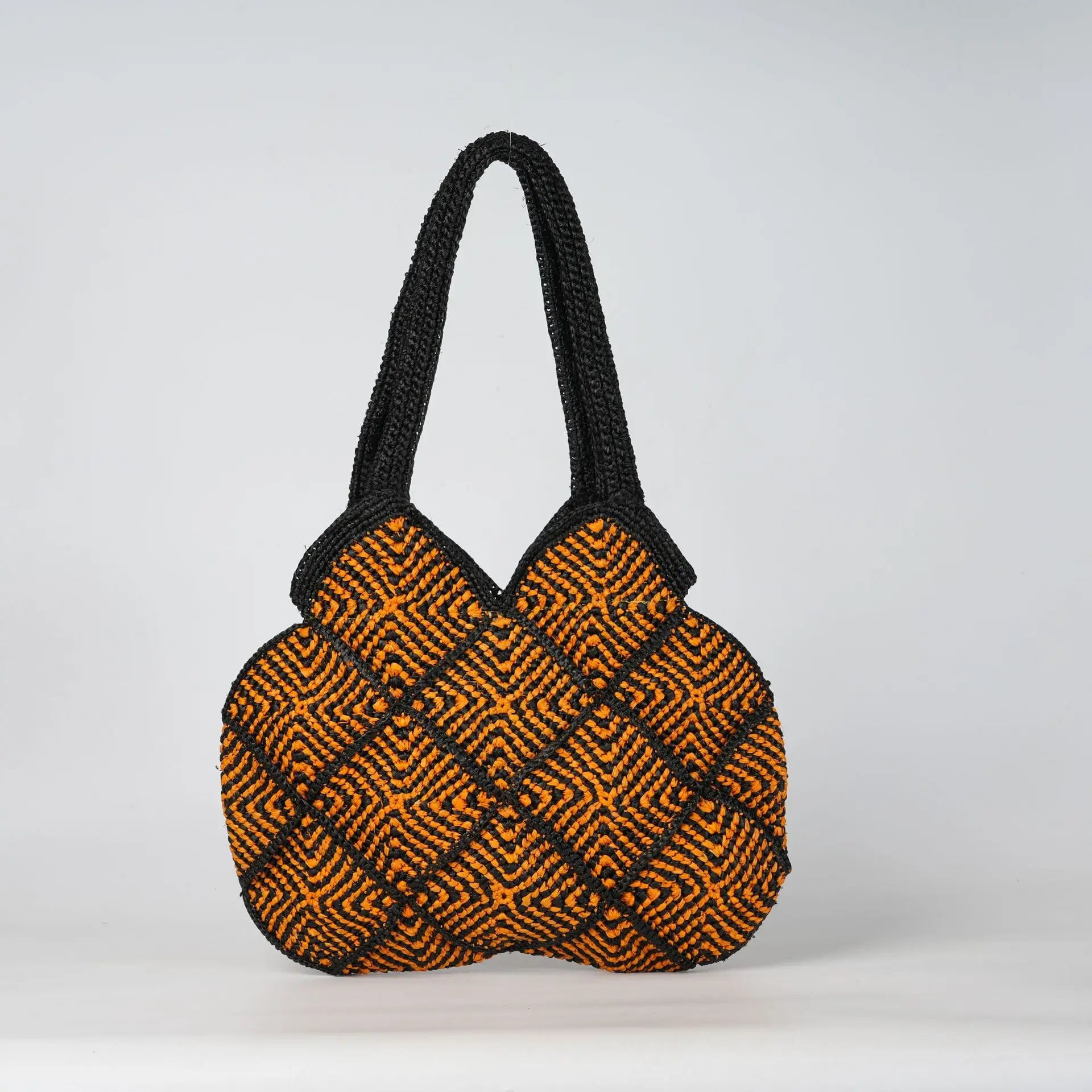 Boho black and orange crochet tote bag with geometric diamond pattern and sturdy shoulder straps.