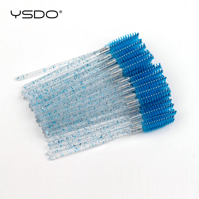 Disposable eyelash wands with blue glittery clear plastic handles and blue nylon bristles for grooming lashes.