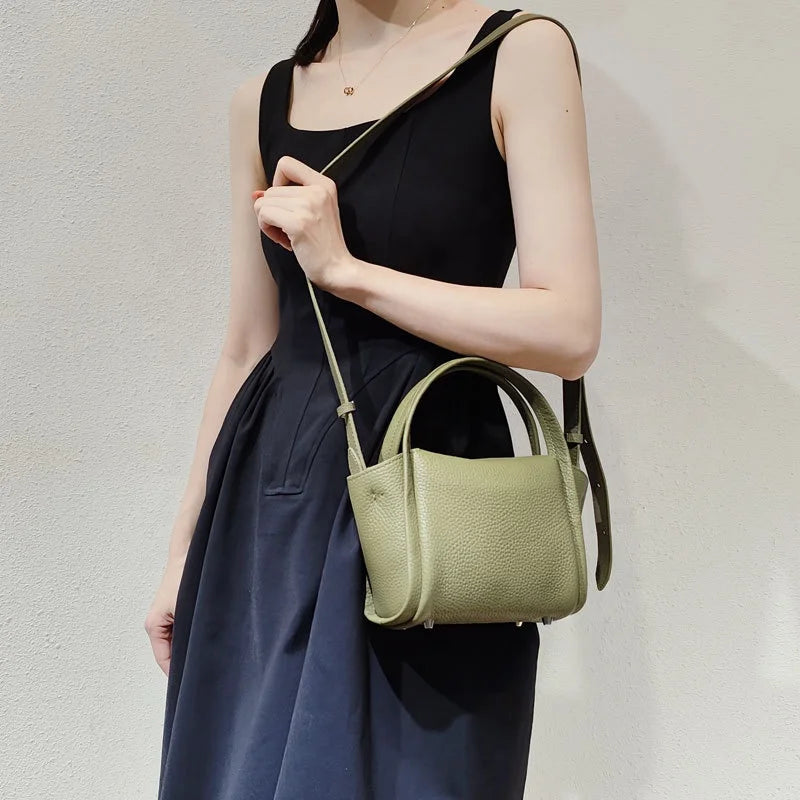 Sage green pebbled leather designer crossbody handbag with top handles, styled as a casual, structured Yuanbao purse.