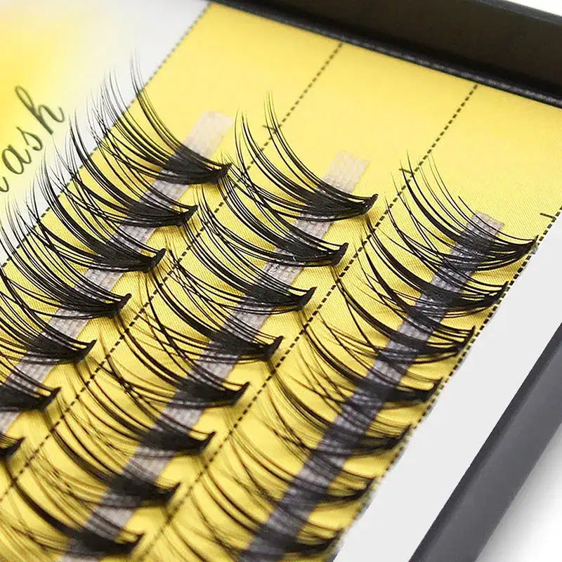 Black 20D Russian volume eyelash clusters arranged in neat rows on a yellow tray.