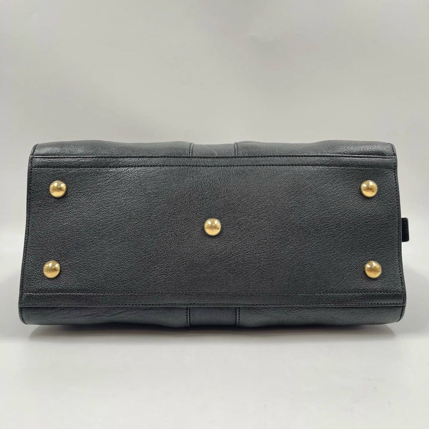 Black genuine leather pillow handbag with gold-tone metal feet. Retro unisex designer bag base.