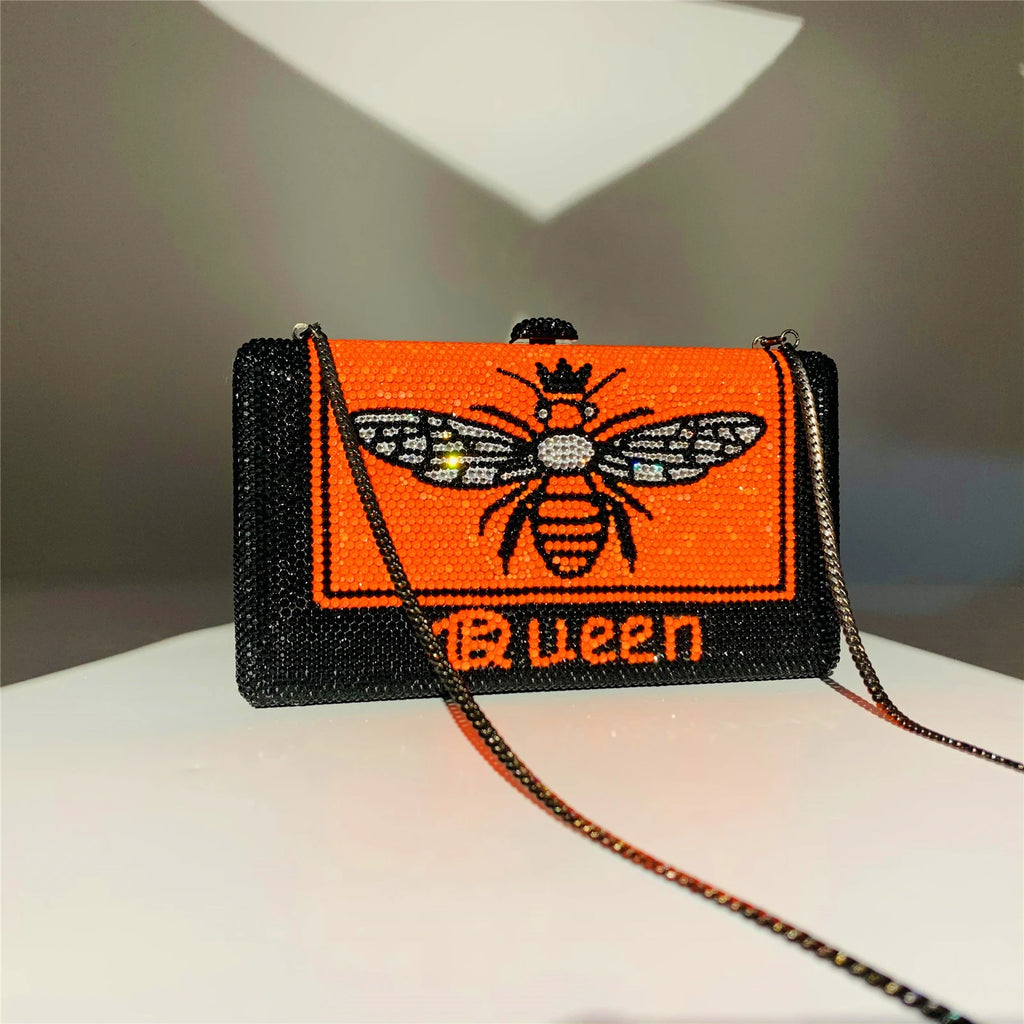 Black and orange rhinestone hard-shell evening clutch with Queen bee pattern and detachable chain strap.