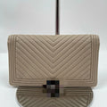 Pre-owned designer tan leather wallet with chevron stitching and front hardware. Elegant luxury fashion accessory.