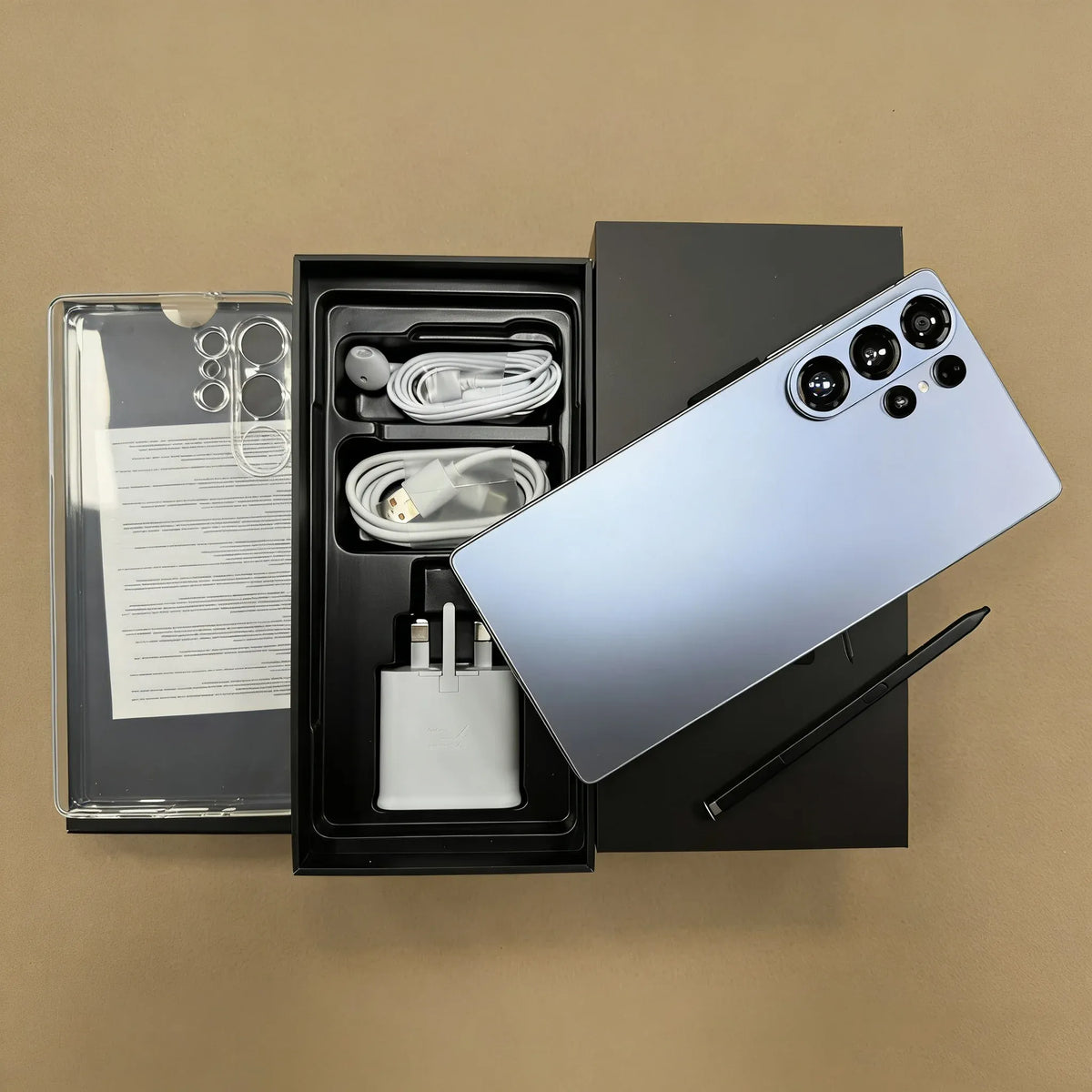 Unboxed S26 Ultra 5G smartphone set: phone back, cables, charger, and manual in box.