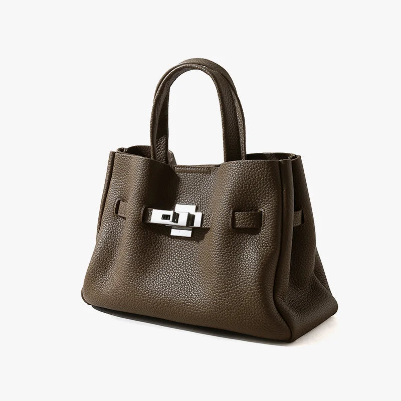 Taupe pebble grain leather handbag with top handles and a silver-tone classic metal lock closure, old money aesthetic.