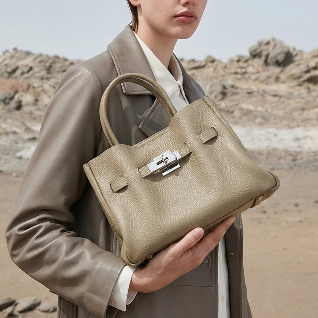 Taupe genuine leather satchel, old money aesthetic with silver lock, structured top-handle trunk bag.