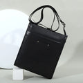 Black genuine leather business casual crossbody tote bag with slim vertical profile, adjustable strap, and rivet studs.