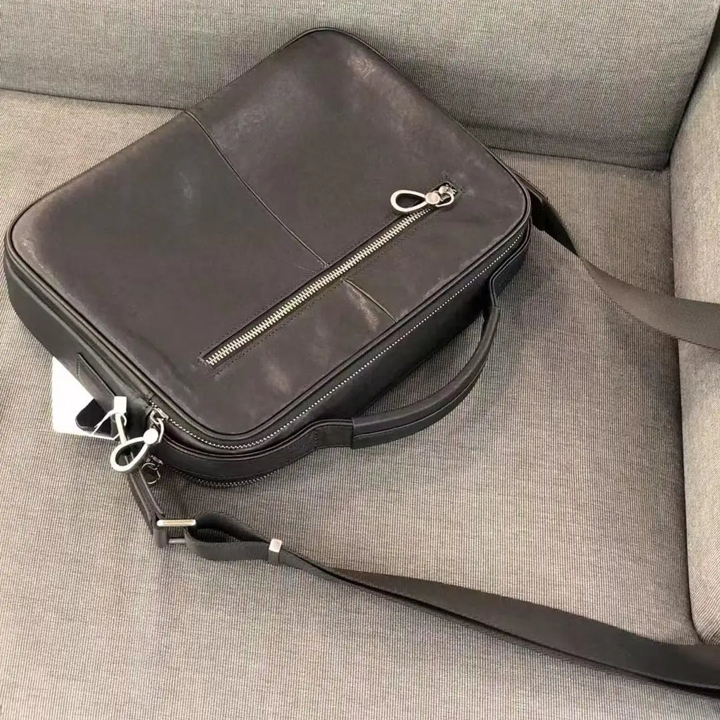 Vintage black cowhide leather messenger bag, small horizontal satchel with front zip pocket and adjustable strap.